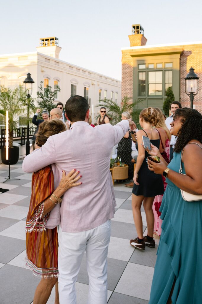 party guests socializing, enjoying drinks and snack son the rooftop at the le james wedding and gala venue in Charleston, SC